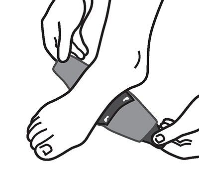Opening hook and loop strap and placing arch support brace under arch of foot.